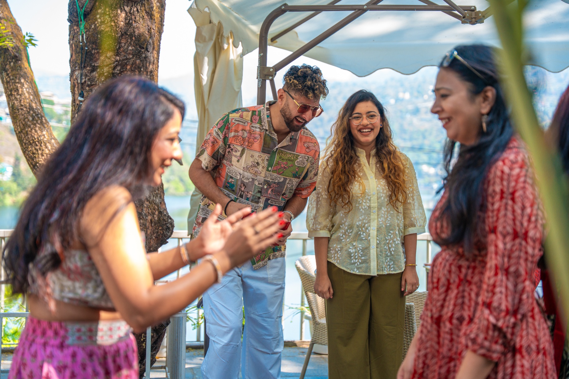 Guests laughing together on a lakeside terrace